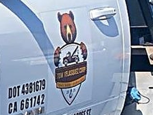 Logo de Tow Velasquez Corp en la puerta, con los números DOT y CA